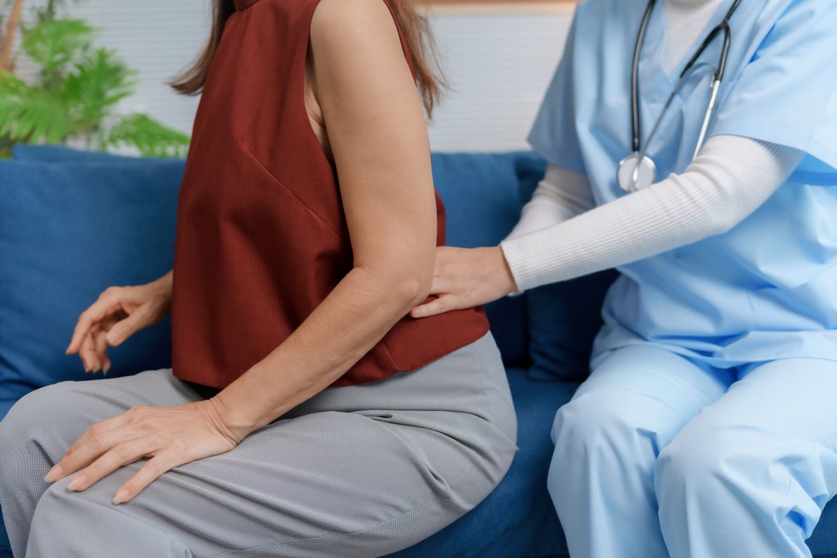 A nurse treats an injured woman's back.
