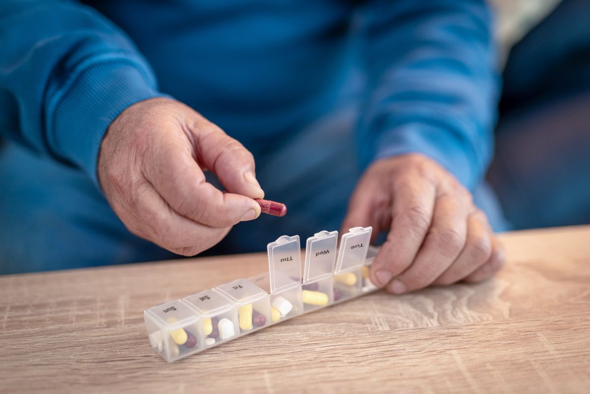 An elderly person organises medication.